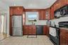 Well equipped and ample kitchen featuring wood cabinetry, recessed lighting, tile flooring and pantry