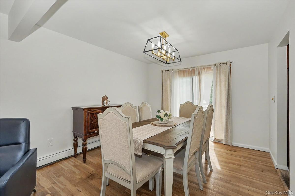 Cheerful dining room featuring wood flooring and sliding glass doors to deck over looking large and level back yard