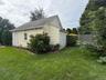 Detached  2 car garage with vinyl siding, a pitched roof, a single window, Door on the side.