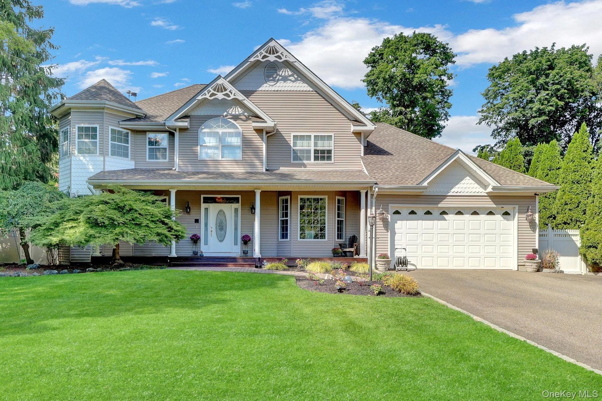 Two-story residence featuring light-colored siding and a covered front porch