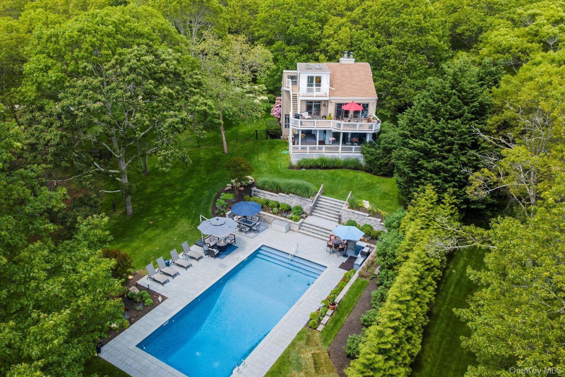 View of subject property featuring a forest and a pool