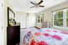 Primary bedroom with large windows, large closets, hardwood floors and an en-suite bathroom