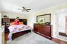Primary bedroom with large windows, large closets, hardwood floors and an en-suite bathroom