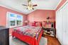 Large second bedroom with high ceilings, big windows and hardwood floors