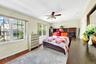 Primary bedroom with large windows, large closets, hardwood floors and an en-suite bathroom
