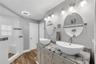 The primary bathroom has a large corner shower with multiple showerheads and built-in bench, dual sinks, linen closet storage and private water closet