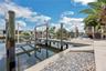Low-maintenance stone landscaping enhances the outdoor space, while a second outdoor shower is conveniently located on the first dock piling.