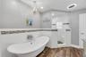 Stunning modern clawfoot tub, corner shower with multiple showerheads and bench in Owner's ensuite.
