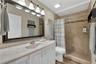 The guest bathroom has been updated with floor to ceiling tile in a spacious walk-in shower.