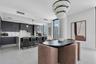 Designer dining area framing quartz waterfall island.