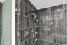 Frameless glass shower with rain fixture and dual shower heads.
