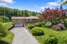 Ranch-style house featuring a garage, asphalt driveway, and a front yard