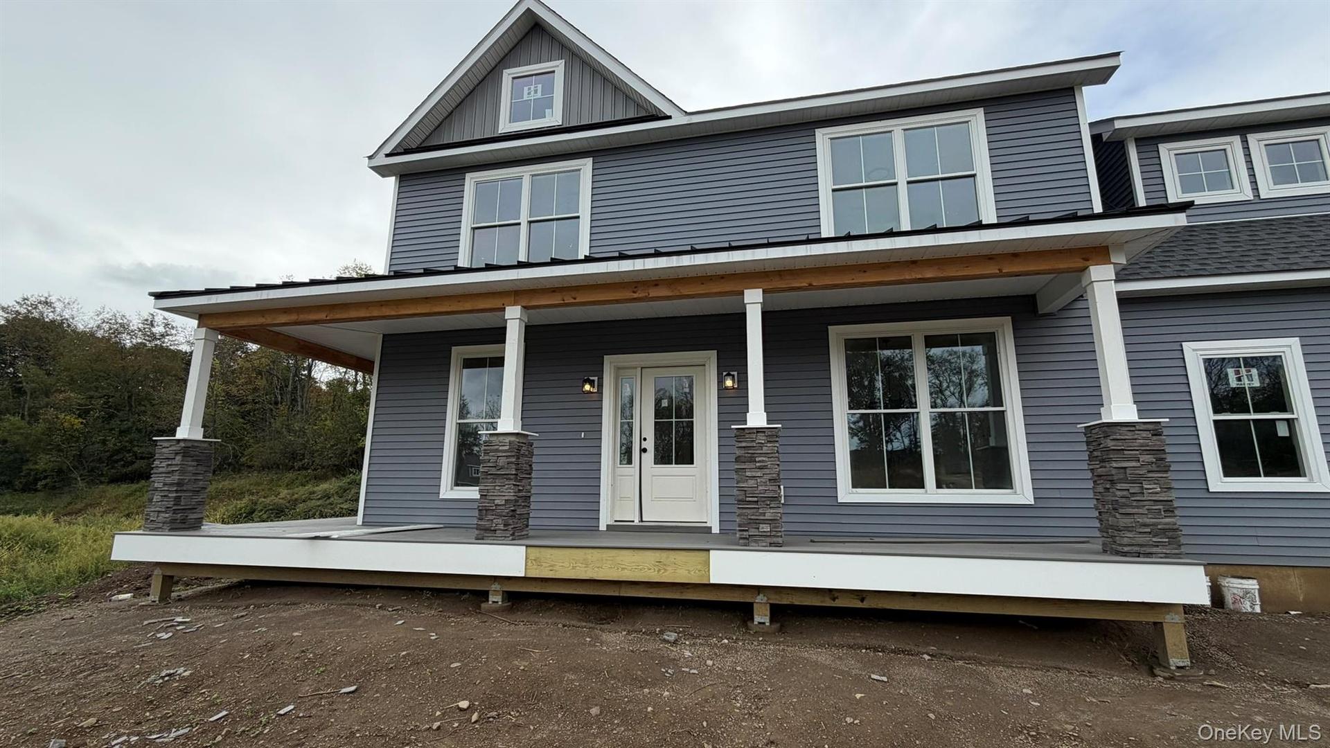 Welcome come to the Fennel, featuring blue siding, white trim, a dark shingle roof, a black metal porch roof, and multiple dormer windows.