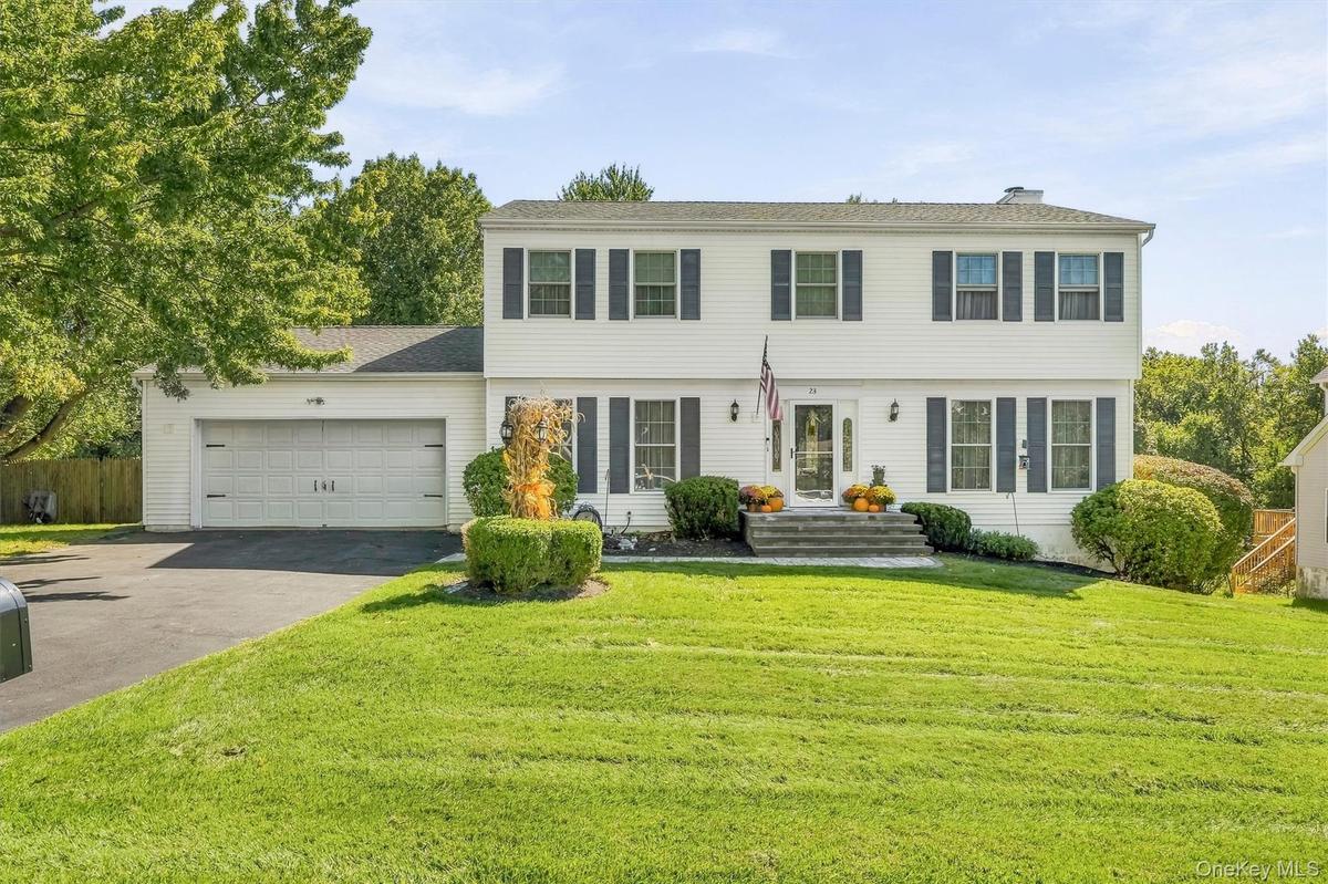White siding exterior with dark shutters, attached two-car garage, and established front landscaping