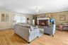 Living area with a baseboard heating unit, light wood-style floors, ornamental molding, a fireplace, and baseboards