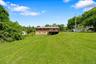 View of green lawn with stairway and a wooden deck