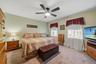 Carpeted room featuring a ceiling fan with integrated lighting, two windows, and light-toned walls