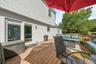 Expansive wood-finish deck with white siding exterior and sliding glass door
