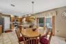 Kitchen featuring wood-finish cabinetry, tile flooring, stainless steel appliances, and a peninsula with countertop seating