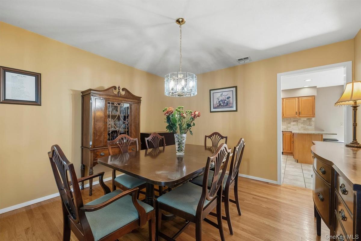 Hardwood flooring throughout featuring a decorative chandelier