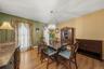 Hardwood flooring throughout, with a crystal chandelier, and large window with decorative valance