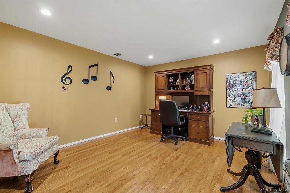 Recessed ceiling lighting, wood-finish flooring, and a window with natural light