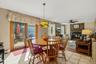 Bright dining area featuring a wood-finish table with matching spindle-back chairs, ceramic tile flooring, and abundant natural light from French door