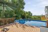 Expansive wood deck with a built-in swimming pool and wood railing