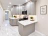 Kitchen featuring light gray cabinetry, white countertops, tile flooring, stainless steel appliances, and recessed lighting