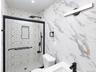 Walk-in shower with black-framed glass enclosure, patterned tile shower surround, and a rain showerhead