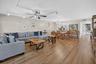 Spacious open-concept living area featuring wood-finish flooring, recessed lighting, and ceiling fan