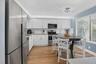 Kitchen featuring white shaker cabinetry, stainless steel appliances, wood-finish flooring, and a white subway tile backsplash