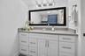 White vanity with shaker-style cabinetry, a built-in rectangular sink, and a countertop