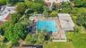 Expansive outdoor pool area featuring a large rectangular pool, a separate hot tub, and a surrounding paver deck