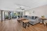 Expansive living area featuring wood-finish flooring, a ceiling fan, and track lighting