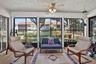 Sunroom featuring multiple large windows, a ceiling fan with light fixture, and wood-finish flooring