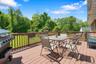 Deck with outdoor dining space, grilling area, and a yard