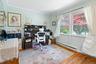 Office area with a baseboard radiator, wood finished floors, and crown molding