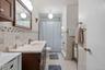 Bathroom with tile walls, vanity, tile patterned floors, toilet, and tiled shower