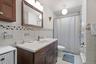 Bathroom with tile walls, vanity, tile patterned flooring, toilet, and curtained shower