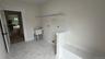 Tiled entry featuring a built-in bench, new shelving and a utility sink.