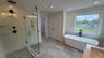 Walk-in shower taking shape with newly installed glass enclosure.