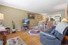 Living area with light wood-style floors, crown molding, baseboards, ceiling fan, and a baseboard radiator