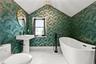Pedestal sink with a matte black faucet, a freestanding bathtub with a floor-mounted fixture, and white tile flooring