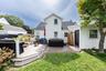 Rear view of the house with multi-level composite deck, white vinyl siding and fenced backyard