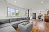 Wood-finish flooring, recessed ceiling lighting, a wood-burning stove with a decorative mantle, and white trim windows