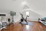 Attic space featuring wood-finish flooring, vaulted ceiling, built-in window bench, and a dormer window