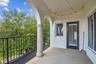 Enclosed outdoor patio overlooking tree-lined street.