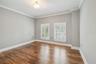 Guest bedroom, featuring hardwood floors and plantation shutters.