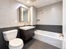 Modern bathroom featuring a floating vanity with integrated sink, illuminated medicine cabinet, rainfall shower head, and two-tone tile walls